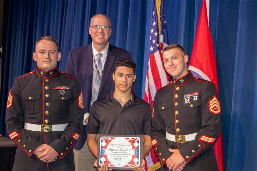 A student is honored for serving in the US Armed Forces after high school